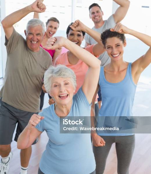 Portrait of smiling people doing power fitness exercise at yoga class in fitness studio